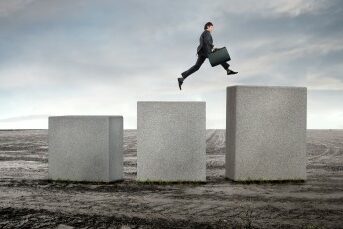 man jumping up large cement blocks in the middle of nowhere