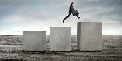 man jumping up large cement blocks in the middle of nowhere