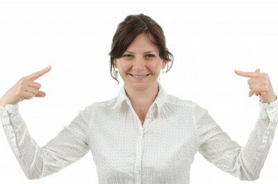 woman smiling pointing at herself