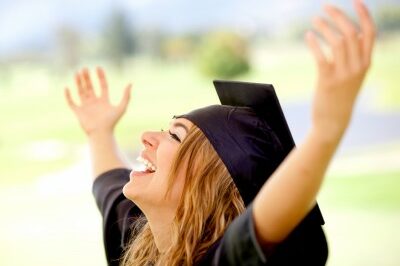woman celebrating her graduation with her hands in the air