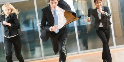 3 business professionals running down a hallway