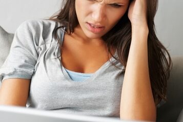 woman stressing while working at a laptop