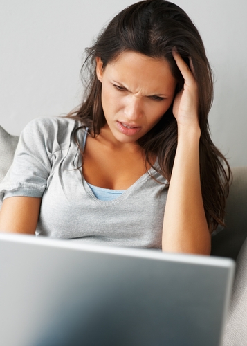 woman stressing while working at a laptop