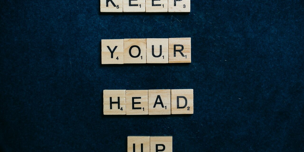 Scrabble pieces spelling out keep your head up for performance improvement plans